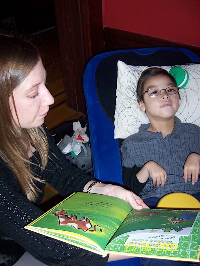 Thomas using his head switch to read a book